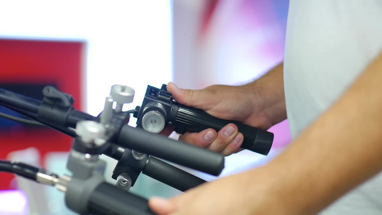 한 남자가 전문 스튜디오 카메라의 초점 및 확대/축소 컨트롤을 작동합니다.