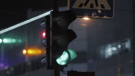 a traffic light is lit in green against the backdrop of a modern building. evening city