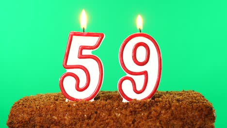 cake with the number 59 lighted candle. chroma key. green screen. isolated