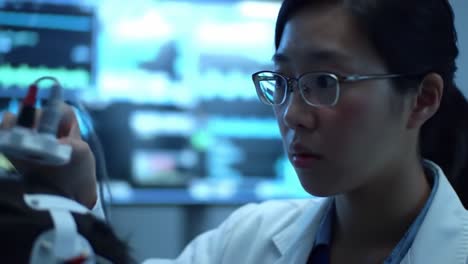 a focused medical professional in a lab setting, attentively monitoring vital signs and conducting tests with advanced equipment, showcasing dedication to patient care and healthcare technology.