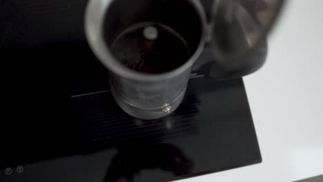 Transition-shot-of-metal-coffee-pot-boiling-on-hot-stove-with-steam