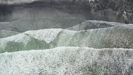 top down aerial shot of big waves breaking on talisker bay, isle of skye