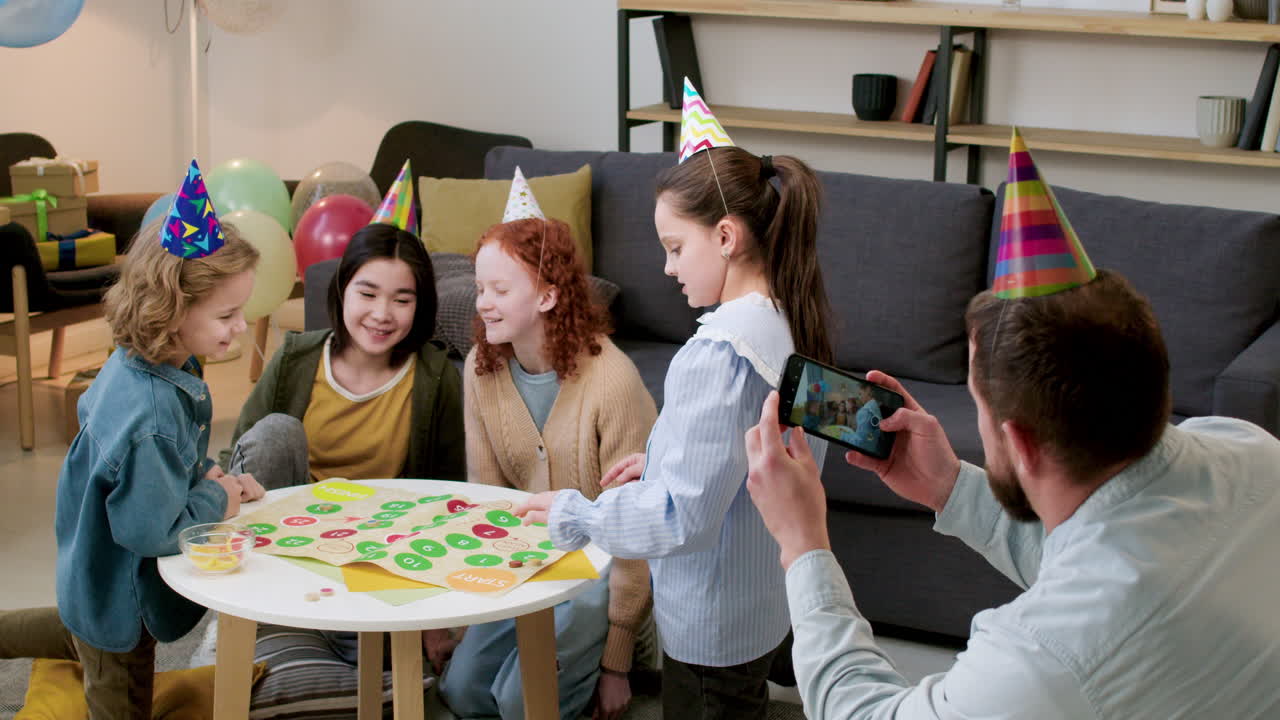Children with party hats playing board game