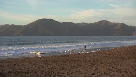 girl walks along baker beach in san francisco california