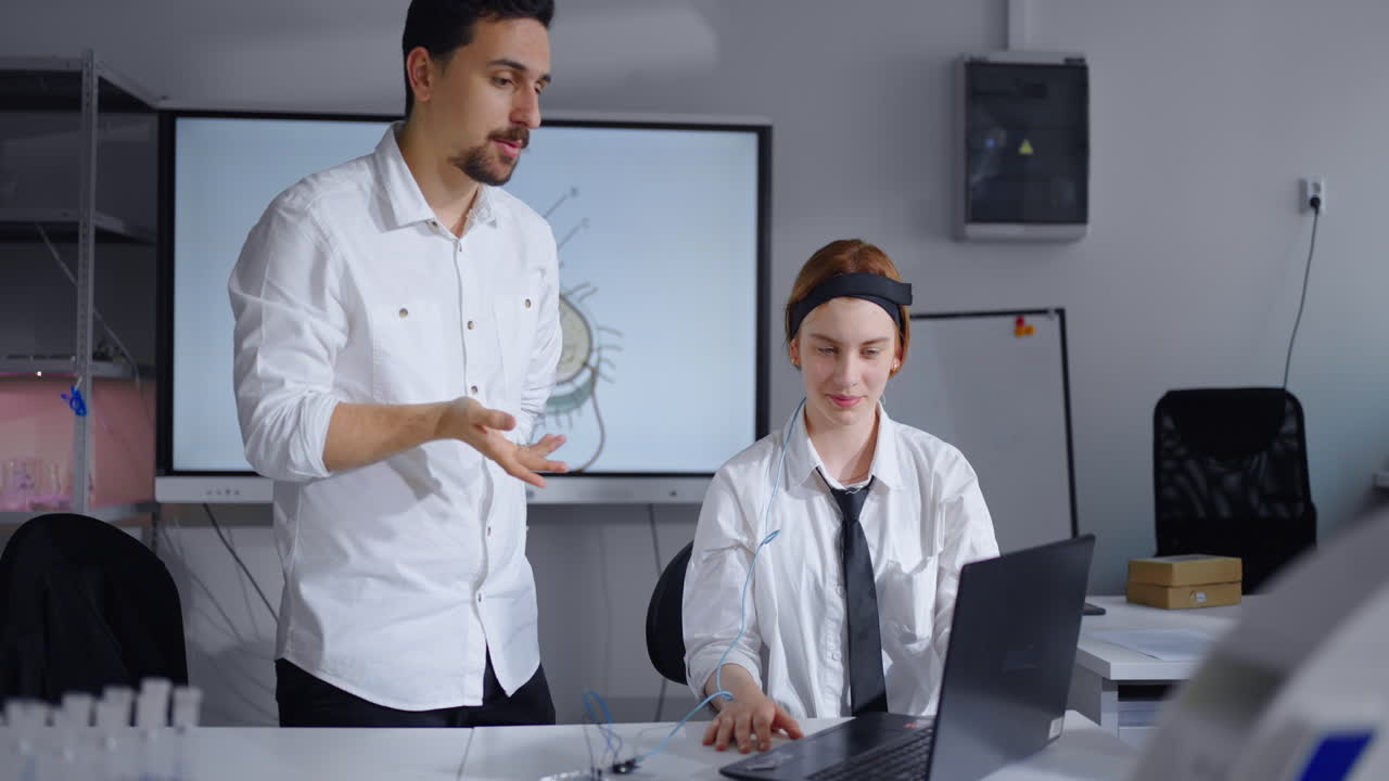 Un uomo e una donna in un'aula, che lavorano insieme a un progetto