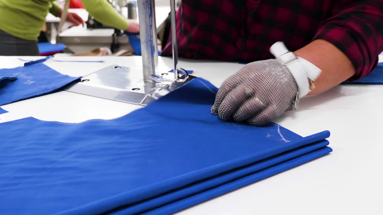 trabajadora con un cuchillo eléctrico cortando tela en una fábrica textil