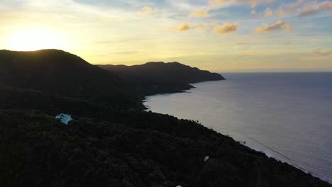 drone view captures a peaceful bay in st. croix with a scenic peninsula bathed in warm, vivid skies reflecting softly on the calm ocean waves in the quiet tropical morning