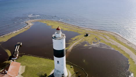 aerial footage of historic lighthouse tall john pier on öland, sweden in baltic sea built by russian war prisoners on south cape island flooded water surrounding old building tourist attraction