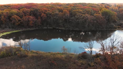 drone-flight-left-over-forest-lake-with-colorful-autumn-trees-4k-Illinois