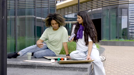 woman and woman painting placards for the environment protest