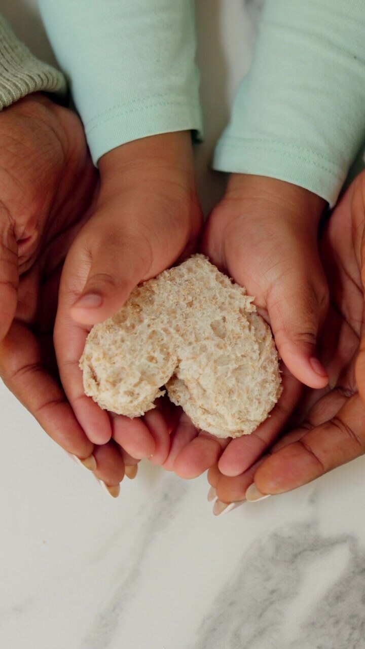 Parent and Child Holding a Heart-Shaped Sandwich Together