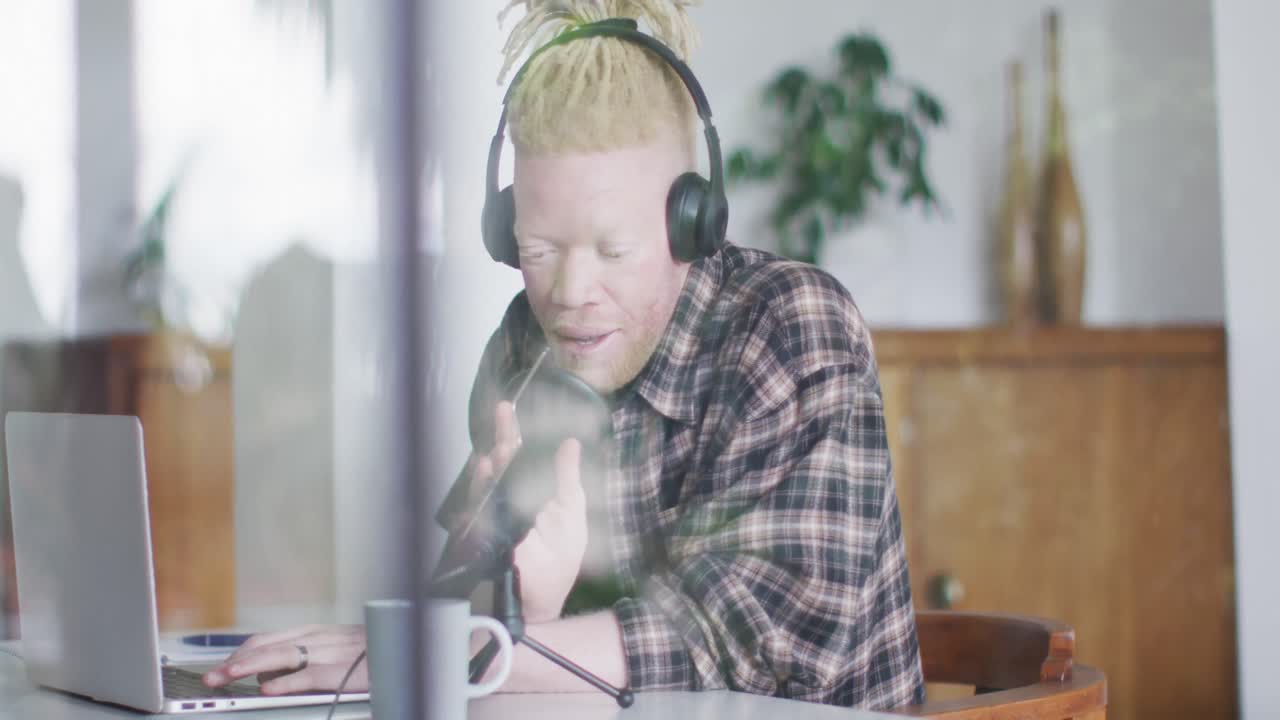 Happy albino african american man with dreadlocks making podcast