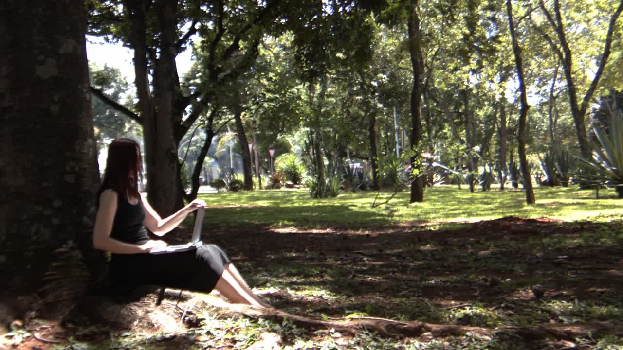 joven empleado de oficina cierra la computadora portátil y se toma tiempo para disfrutar de la naturaleza de la ciudad