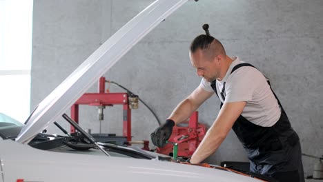 mechanic working on a car engine in a garage