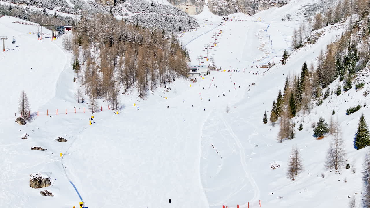 Aerial drone view of people skiing in Colfosco in South Tyrol, Dolomites, Northern Italy
