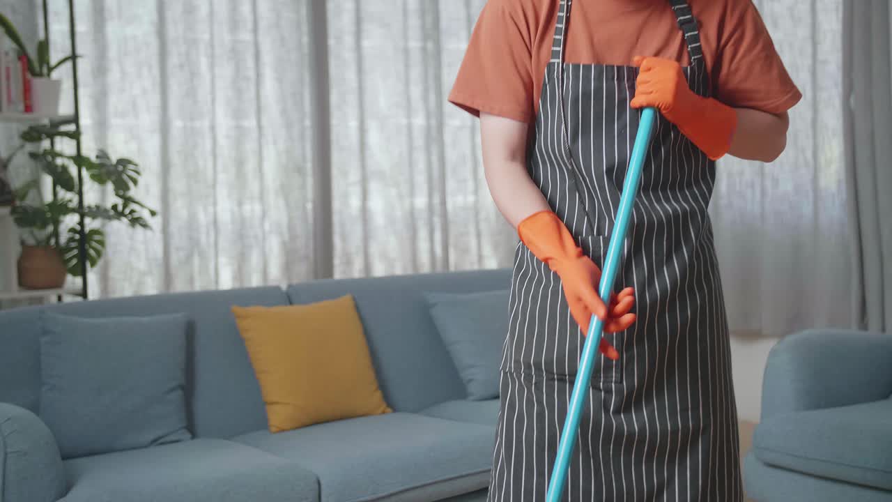 hombre limpiando la casa mientras escucha música