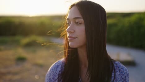 Porträtaufnahme-Einer-Hübschen-Brünetten-Frau,-Die-Die-Landschaft-Während-Des-Goldenen-Sonnenuntergangs-Genießt-–-Zeitlupe