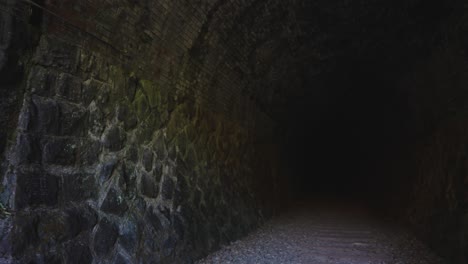 paredes de piedra de un oscuro túnel abandonado a lo largo del ferrocarril fukuchiyama abandonado