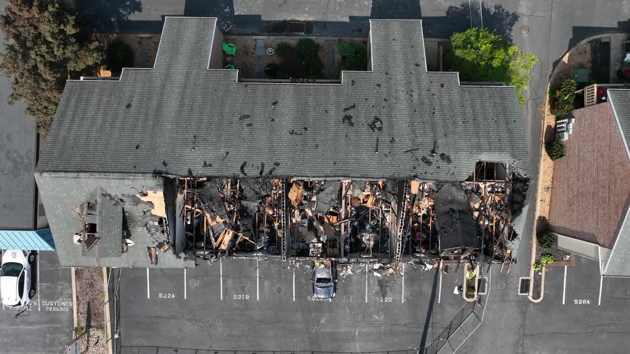 Top down aerial shot of apartment building roof collapsed in after house fire