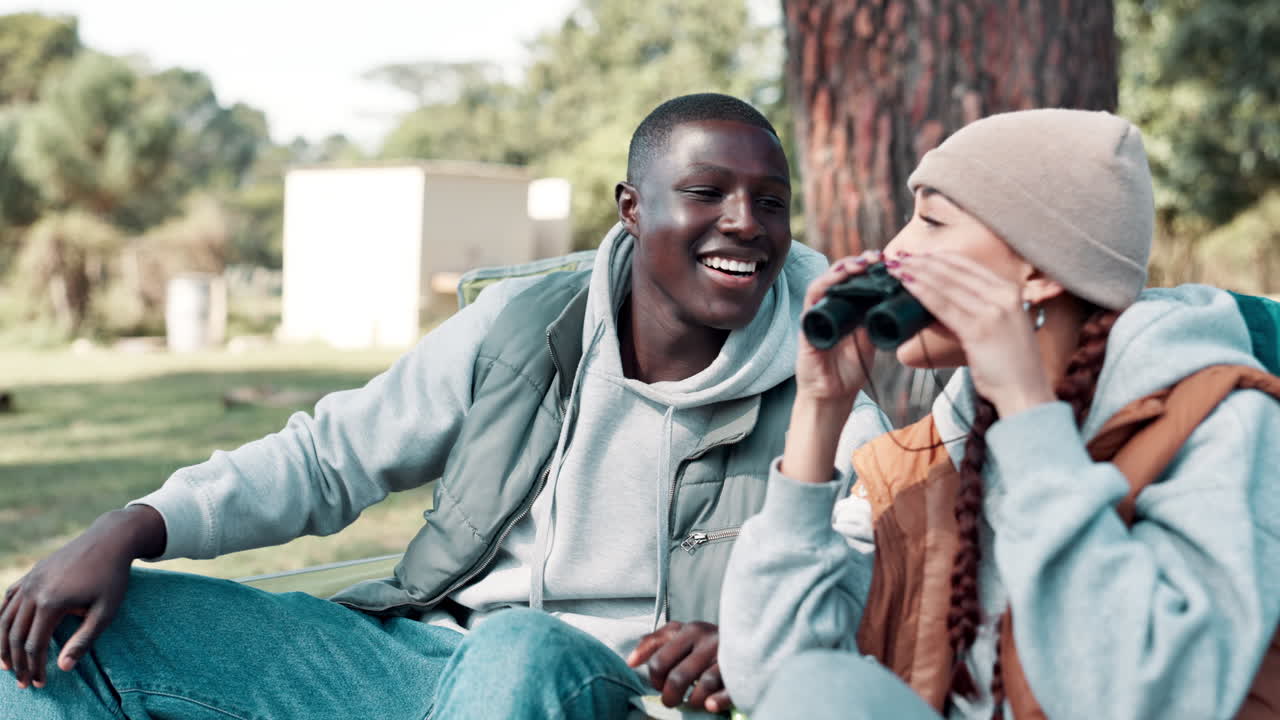 Young couple exploring nature with binoculars