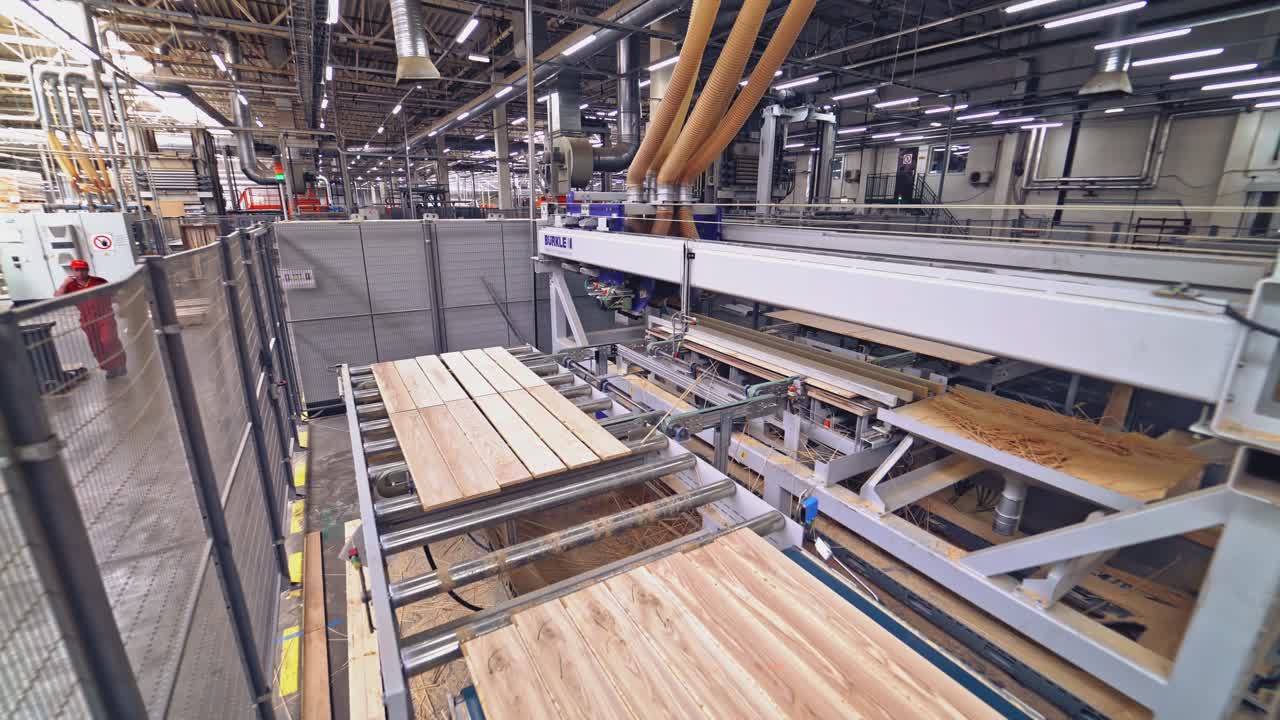 Modern automatic line is grinding the parquet boards with motion to the right and left and moving to another area of work at the plant for the production and sale of parquet.