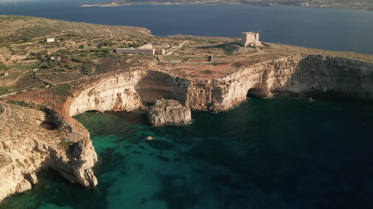 Aerial drone footage over clear turquoise waters of Malta's Blue Lagoon