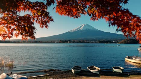 una serena escena de otoño en el lago kawaguchiko, con impresionantes vistas del monte fuji enmarcado por el vibrante follaje rojo de momiji.