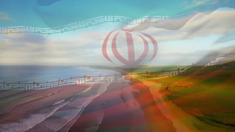 Digital-composition-of-waving-iran-flag-against-aerial-view-of-beach-and-sea-waves