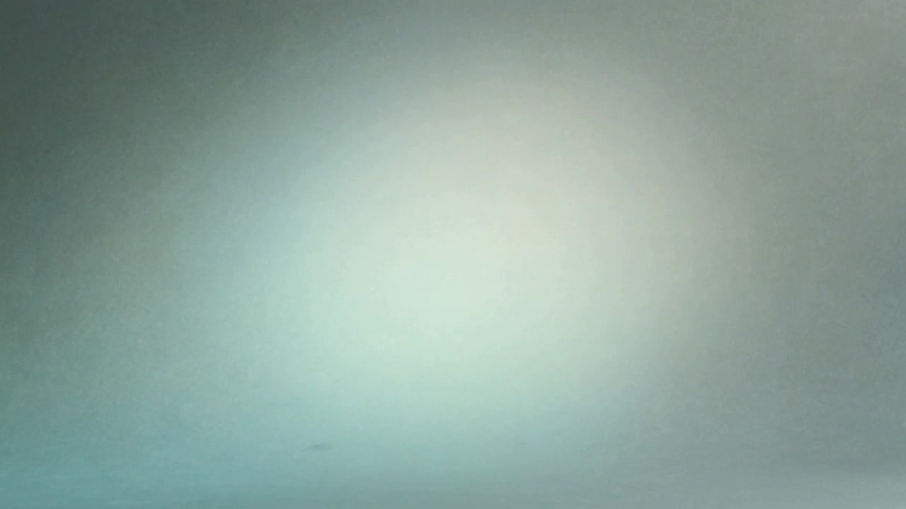 Recording camera capturing soft circular highlight shifting on studio wall, showing lens defocus