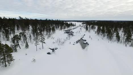 snowy winter landscape with river and hikers