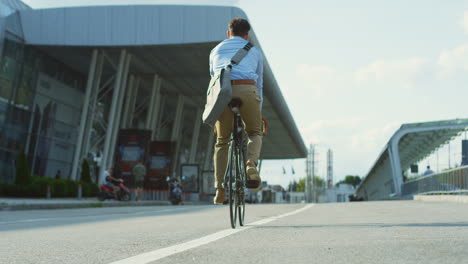 Vista-Trasera-De-Un-Joven-Montando-En-Bicicleta-Cerca-Del-Aeropuerto