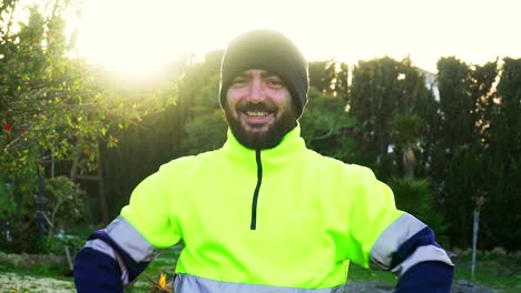 Hombre-Vestido-Con-Ropa-Reflectante-Amarilla-O-Uniforme-De-Trabajador-Público,-Sonriendo-Y-Gesticulando-A-La-Cámara-Con-Las-Manos