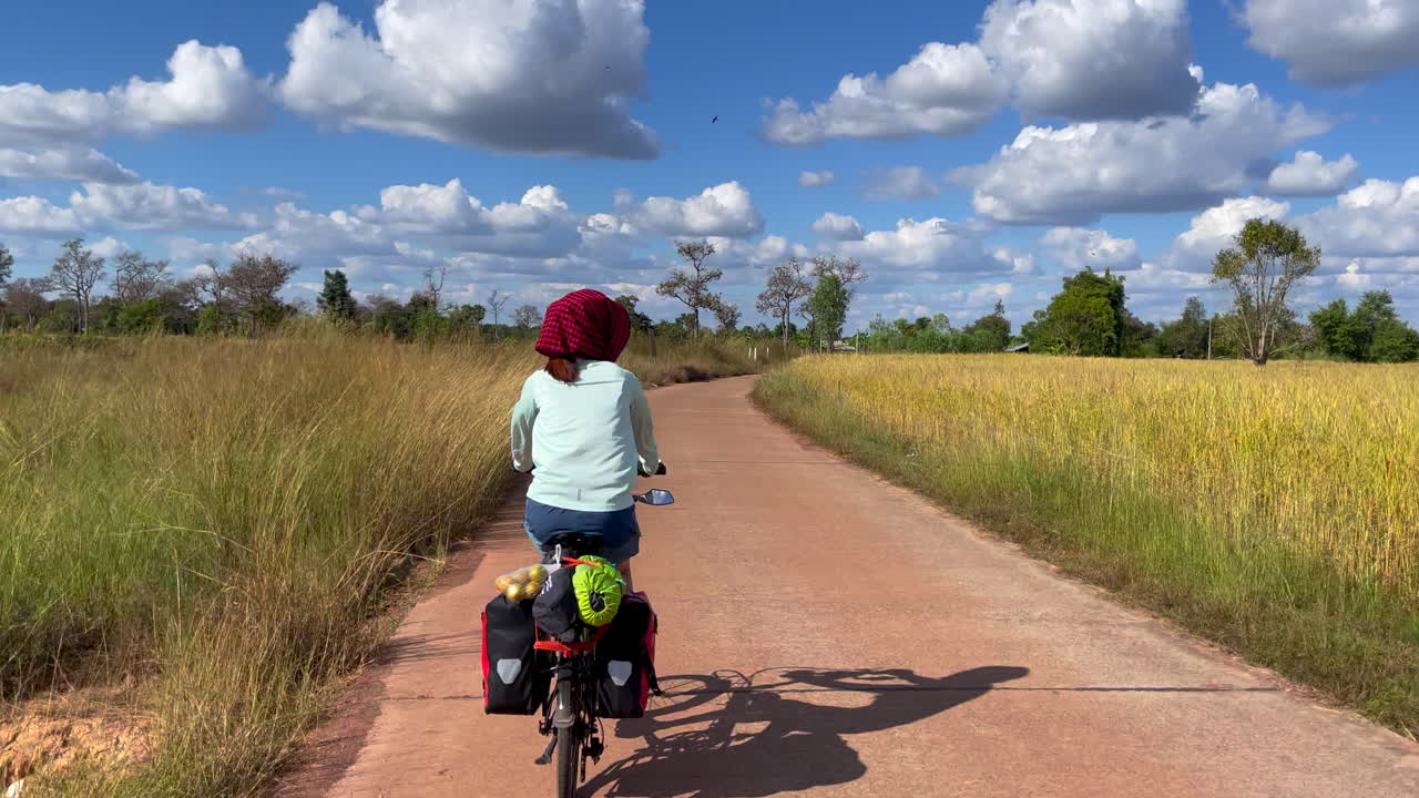 뒷좌석에 패니어와 식료품을 싣고 자전거를 타고 출퇴근하는 여성의 다이내믹한 영상
