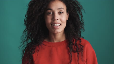una mujer afroamericana sonriente sobre un fondo azul.