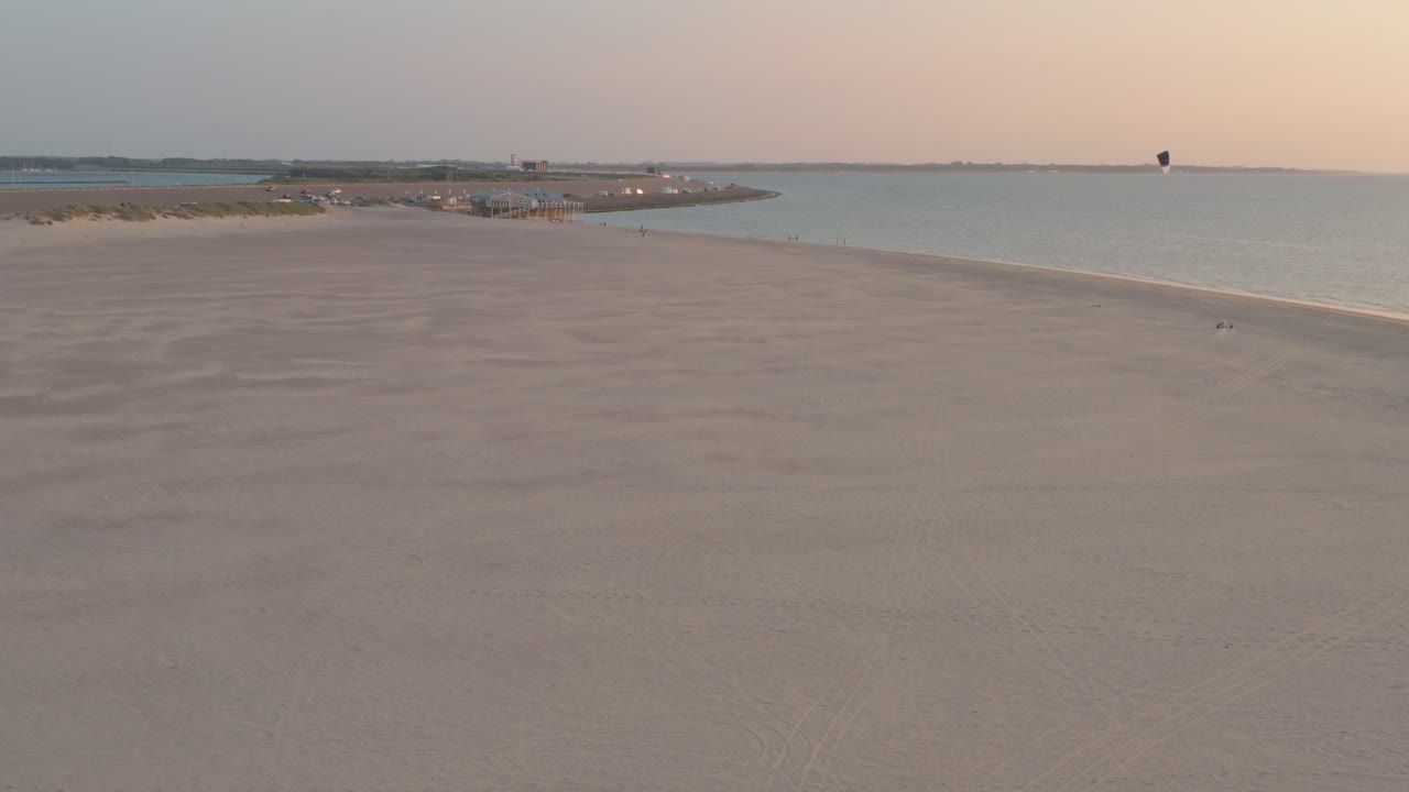 시네마틱 드론 - 네덜란드 북해의 zeeland에서 버기카이팅과 함께 일몰의 녹색과 모래 자연 해변의 공중 파노라마 샷, 네덜란드, 25p