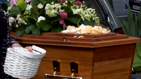 closeup shot of a funeral casket or coffin in a hearse or chapel or burial at cemetery