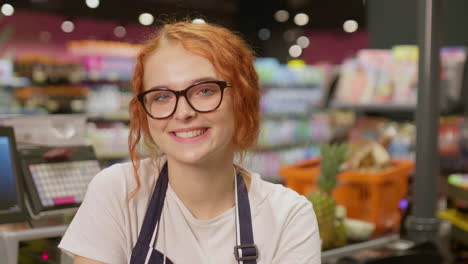 young sales clerk woman smiling and looking at the camera in a supermarket