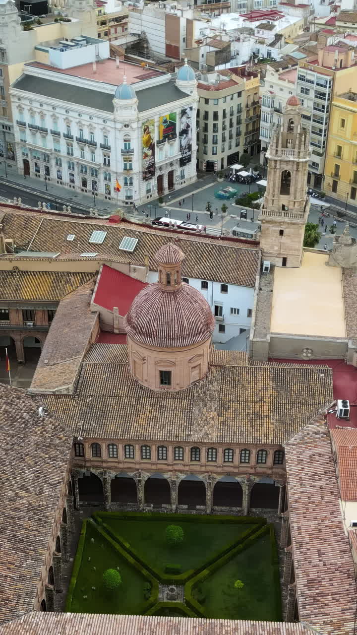 Aerial drone view of the Santa Catalina Church surrounded by buildings in Valencia, Spain. Vertical