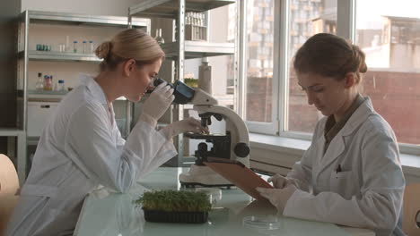 scientists using microscope and tablet in lab