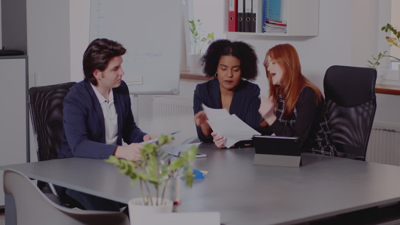 Riunione di lavoro con un team diversificato che discute documenti e collabora