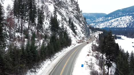 沿著 yellowhead highway 5 沿著 kamloops 附近冰凍的北湯普森河谷,一輛紅色車的觀點,令人驚的雪覆蓋的山地風景