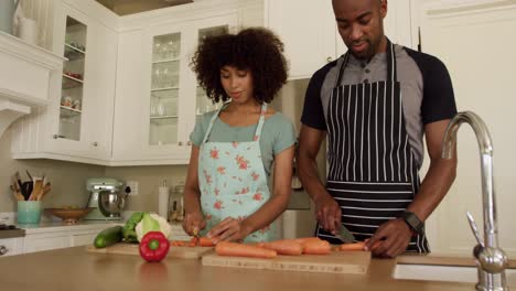 happy mixed race couple cooking and dancing in their kitchen