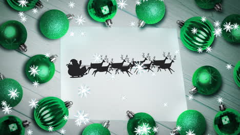 copos de nieve sobre santa claus en trineo siendo tirados por renos en papel y múltiples bolas verdes