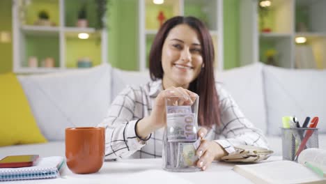 mujer joven feliz ahorrando dinero, planeando invertir en su futuro.
