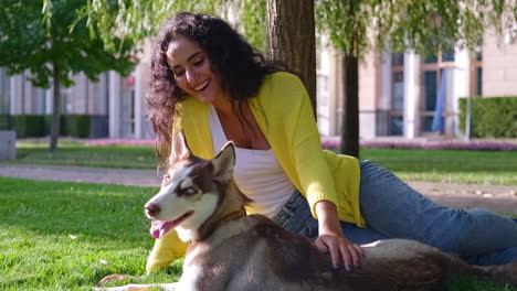 woman and husky dog relaxing in a park