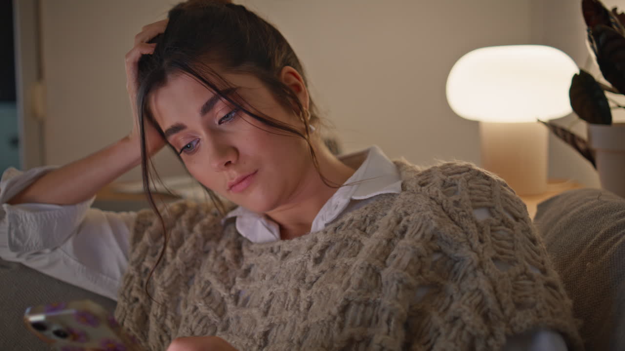 어두운 집에서 휴대전화를 사용하는 늦은 여성. 스마트폰을 읽는 여인