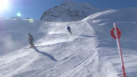 Tourists-skiing-down-the-slopes-of-the-sunny,-Austrian-Alps---static-view