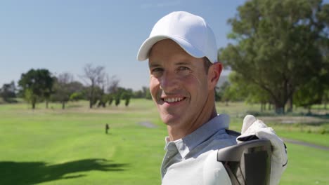 caucasian male golfer smiling at camera on a golf course