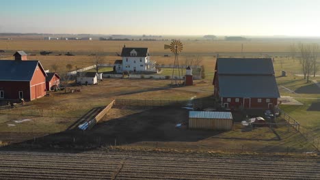 a drone aerial establishing shot of a classic farmhouse farm and barns in rural midwest america york nebraska