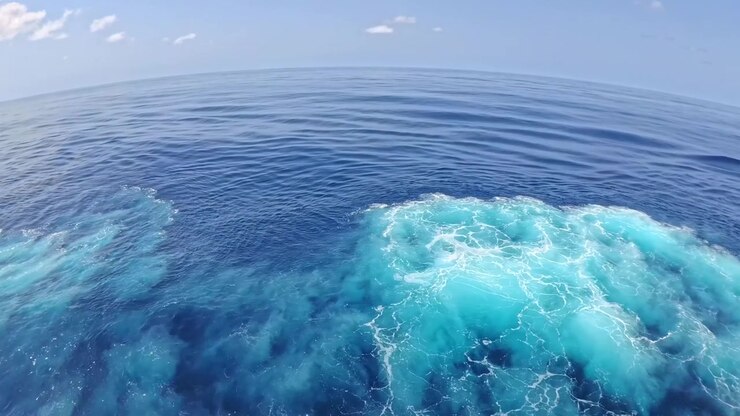 Acqua oceanica blu profondo con scia spumeggiante